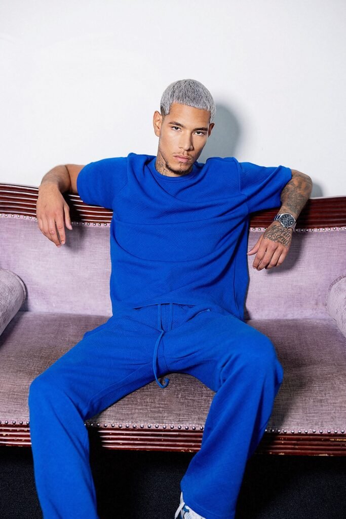 Fashion portrait of male model Juan Lopez wearing a vibrant blue two-piece outfit.